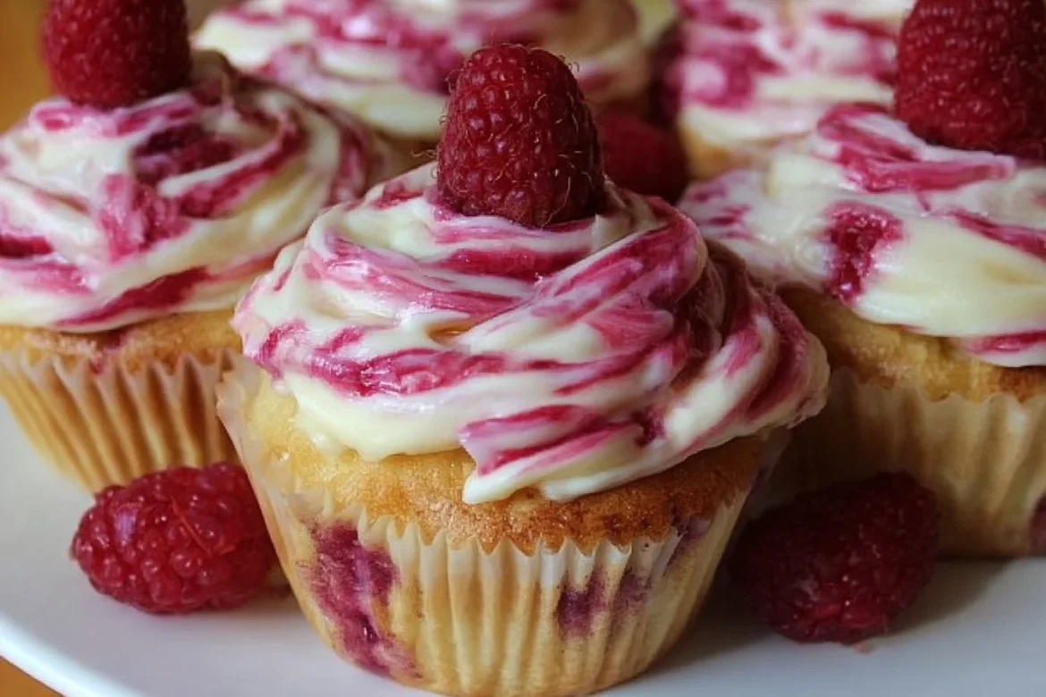 Delicious raspberry swirl cupcakes topped with creamy frosting and fresh berries.