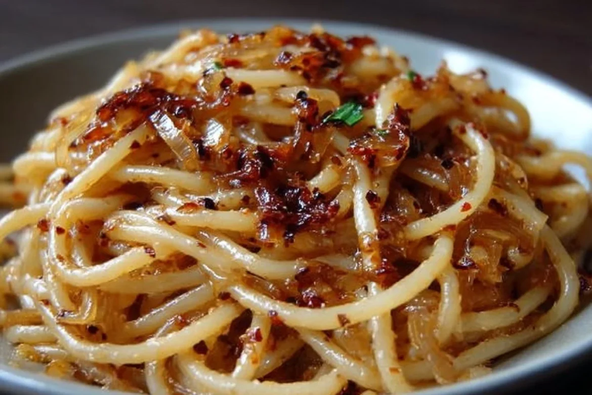 Delicious caramelized onion pasta topped with chili oil for a sweet and spicy kick.