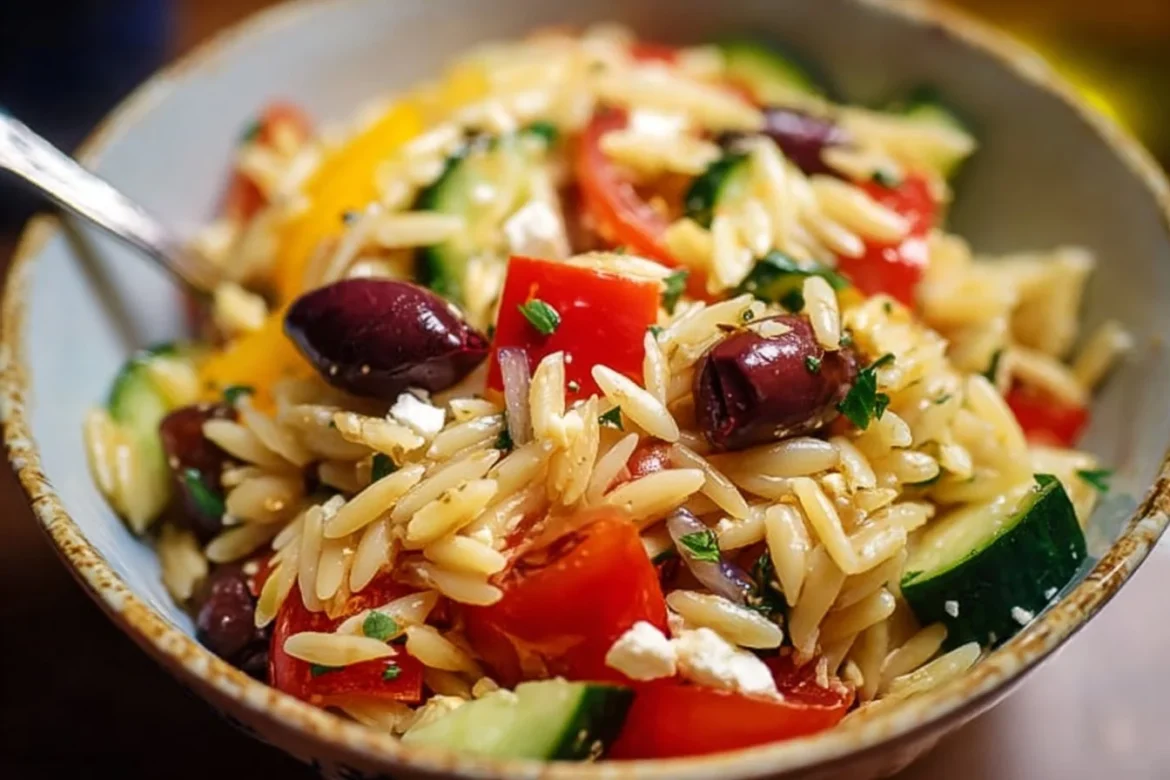 Delicious bowl of Greek Orzo Pasta Salad with vegetables and dressing