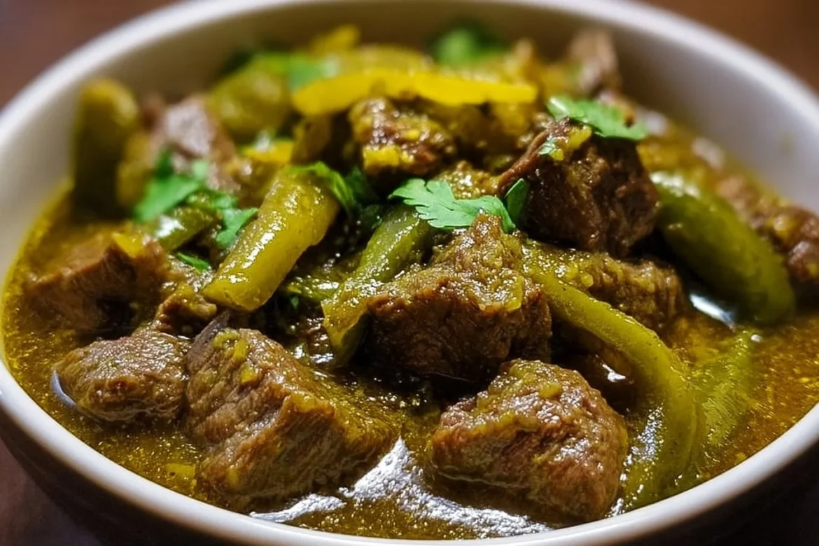 Bowl of Mexican Beef Green Chili topped with fresh herbs and spices
