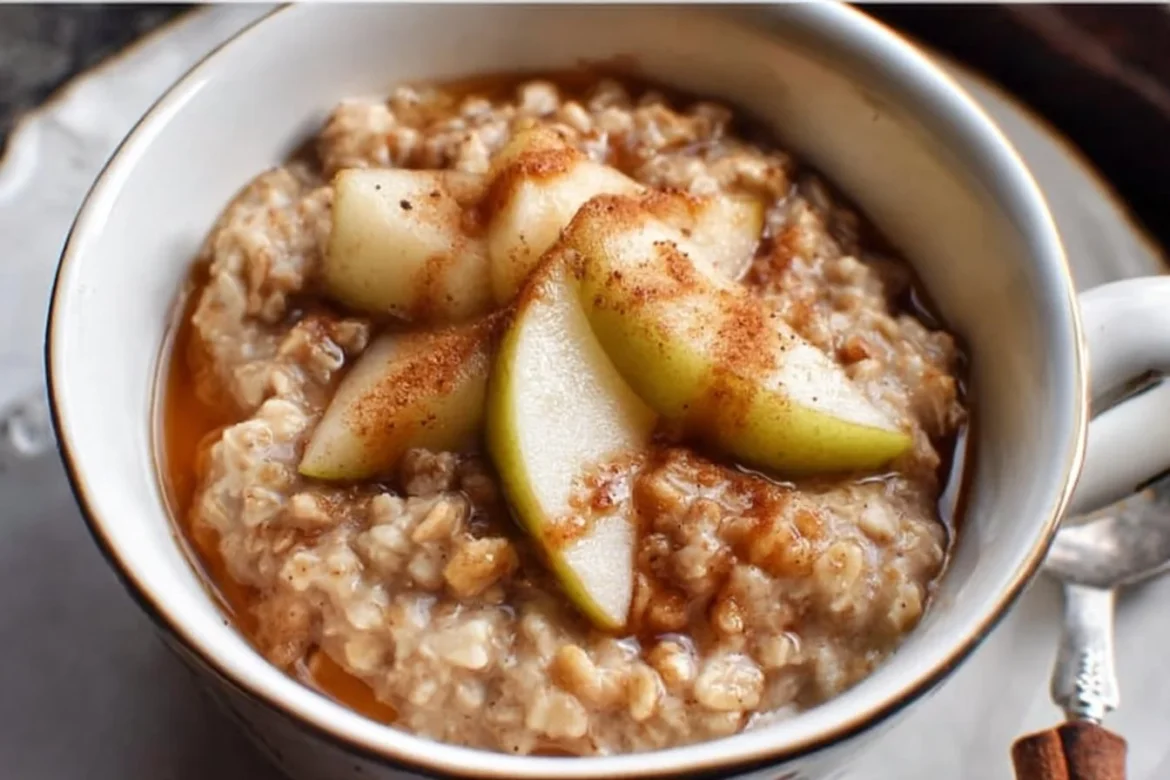 Bowl of spiced pear oatmeal topped with cinnamon and pecans