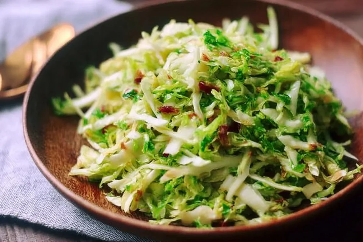 Bowl of Apple Brussels Sprouts Slaw with almonds and dressing