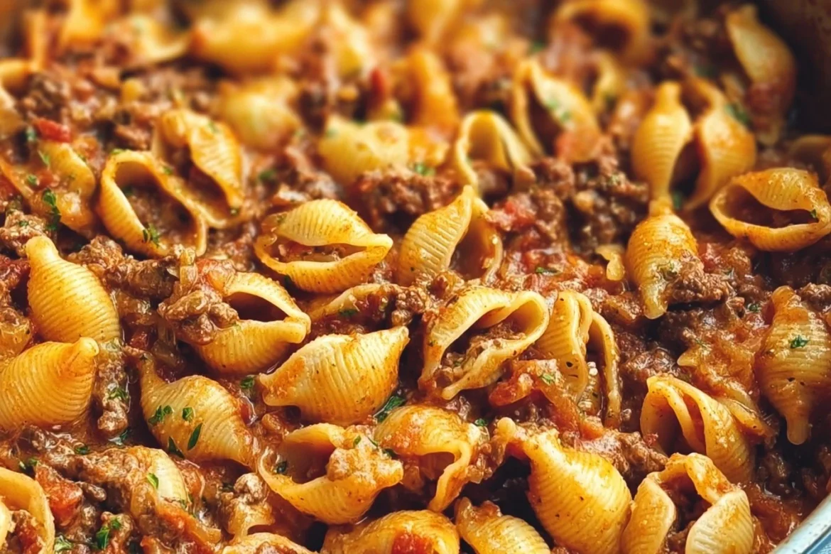 Creamy beef and shells dish served in a bowl with herbs on top