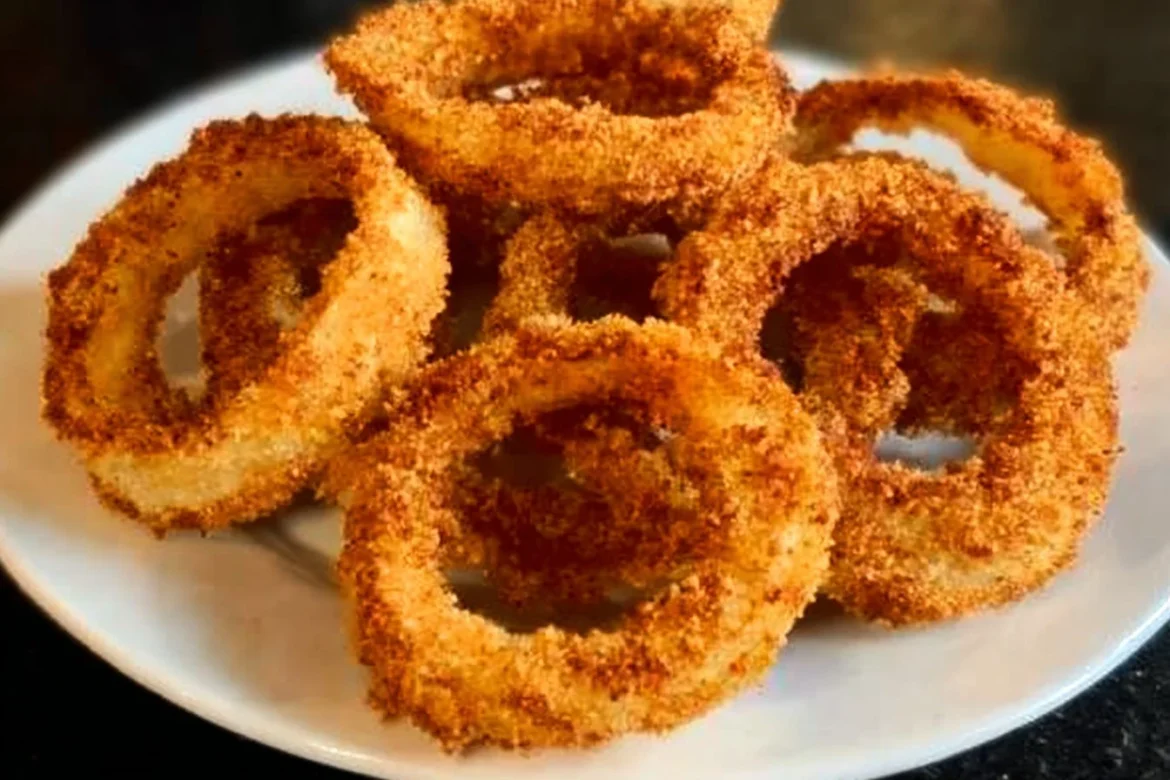 Golden crispy air fryer onion rings served in a bowl.