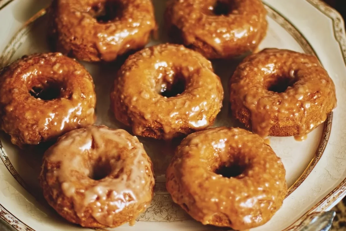 Baked pumpkin donuts topped with maple glaze, perfect for autumn treats.