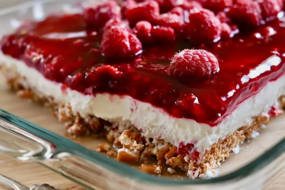 Delicious raspberry pretzel salad with layers of cream cheese, raspberry filling, and crunchy pretzel crust.