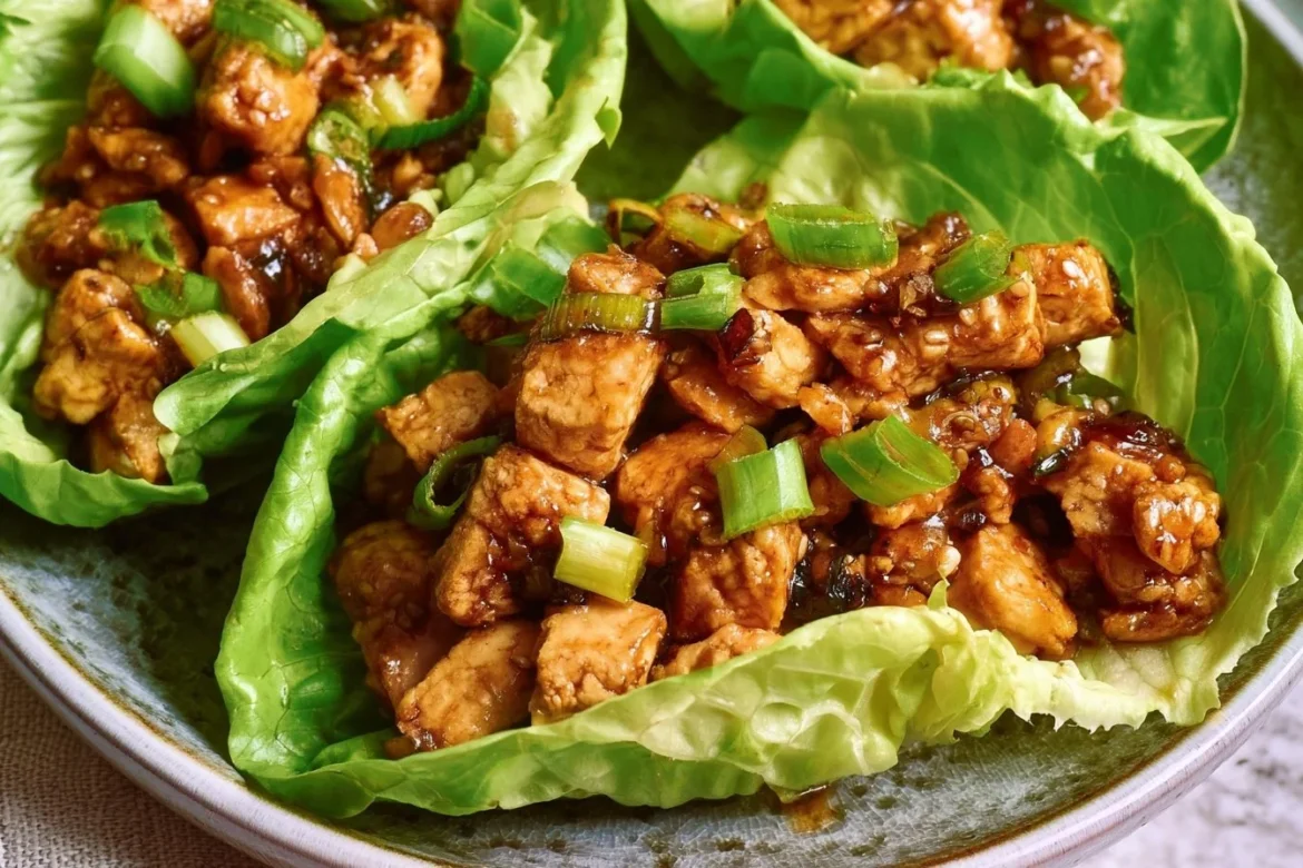 Plate of delicious tofu lettuce wraps filled with fresh vegetables and sauce.