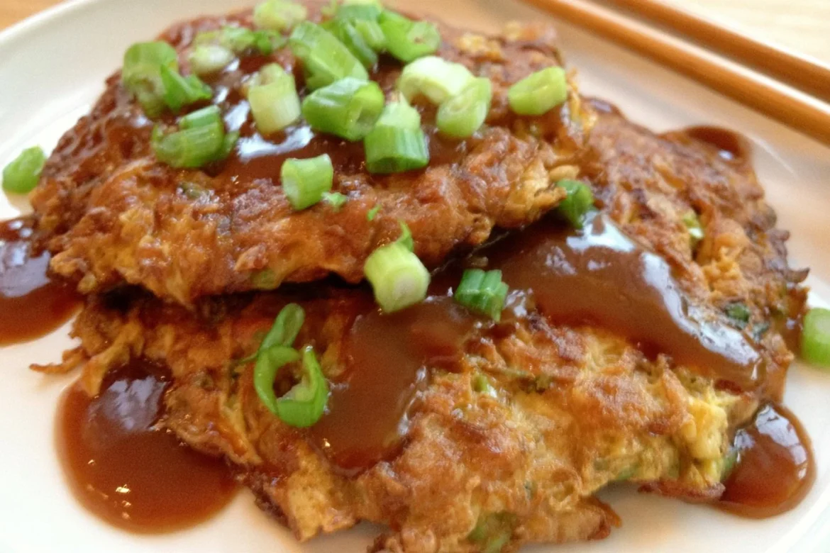 Delicious homemade Egg Foo Young served with savory sauce on a plate