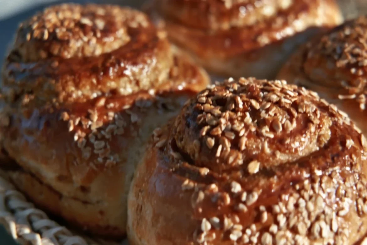 Freshly baked oatmeal molasses rolls on a wooden table