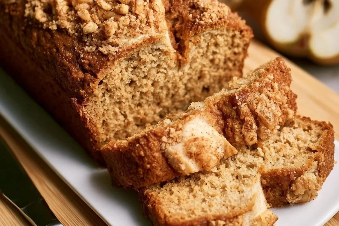 Loaf of freshly baked spiced pear bread with a golden crust and spices